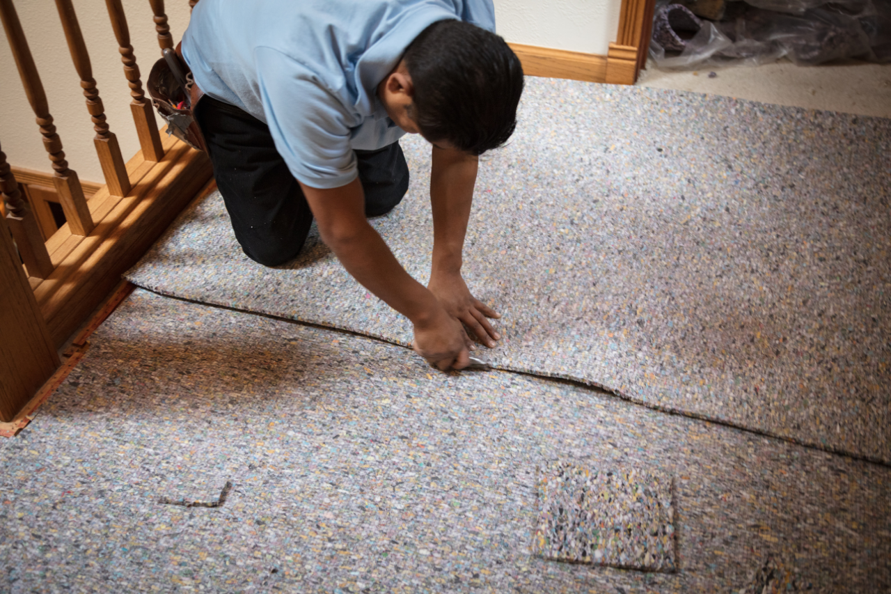 Technician preparing carpet and underlay during a professional repair