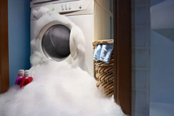 Washing machine overflowing with water and suds